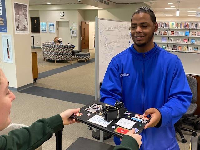 IT staff member passing laptop to an RWU student